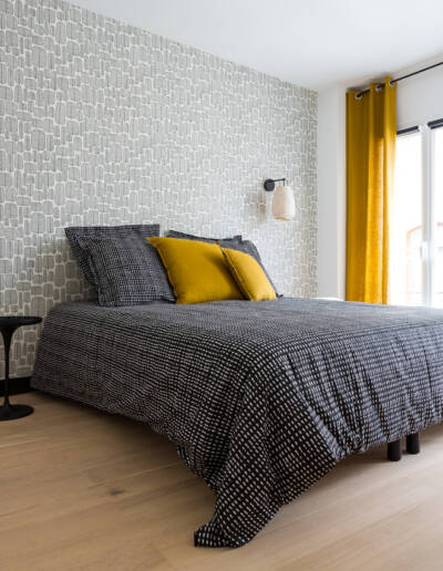 Rénovation d'un appartement de 60m2 à Paris 2ème - La chambre aux motifs noir et blanc rehaussée de jaune moutarde pour les coussion et les rideaux, par Fabienne Boé de Pirey, Architecte d'intérieur UFDI à Paris 75