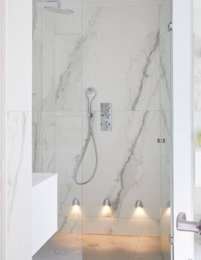 Rénovation et Décoration d'un Duplex à Paris 16ème - La salle de bain avec une douche à l'italienne recouverte de céramique grand format motif marbre, par Fabienne Boé de Pirey, Architecte d'intérieur UFDI à Paris 75
